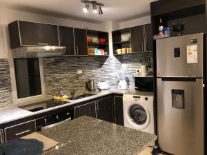 een keuken met een koelkast en een wasmachine bij Departamento, San Bernardo in San Bernardo