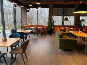 a restaurant with many tables and chairs and windows at Mastersclub in Ternopilʼ