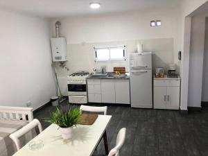 a kitchen with white appliances and a table and chairs at Namaste in Paraná