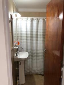 a bathroom with a sink and a shower curtain at Namaste in Paraná