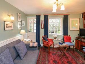a living room with a couch and chairs and a window at 33 Island Street in Salcombe