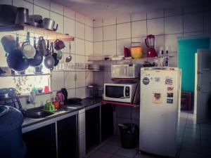 una pequeña cocina con nevera y microondas en Proxima Estacion Hostel, en Maceió