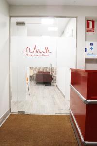 una oficina con una puerta de cristal que conduce a una sala de espera en Albergue Logroño Centro en Logroño