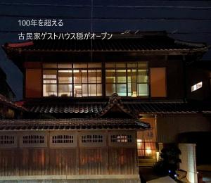 an asian building with an asian roof at night at 古民家ゲストハウス穏 in Sakaide