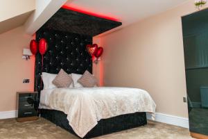 a bedroom with a large bed and a large window at Aphrodite Suites Huddersfield in Huddersfield