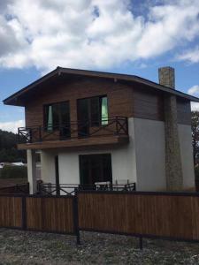 een huis met een terras en een balkon bij Villa Baghdo Bakuriani in Bakuriani