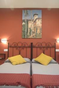 two beds sitting next to each other in a bedroom at Hostal Aresol in Madrid