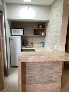 a kitchen with a counter top and a refrigerator at Flat Park Veredas com Vista Serra com geladeira e fogão in Rio Quente