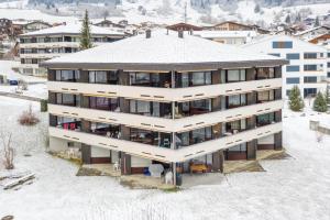 eine Luftansicht eines Gebäudes im Schnee in der Unterkunft Residenza Quadra B223 in Flims