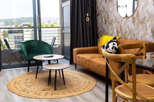 a living room with a couch and chairs and a table at Menlyn Marble Print Apartment in Pretoria