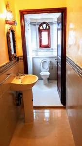 a bathroom with a white toilet and a sink at Dromadaire Gourmand in Zagora