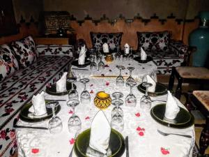 una mesa con copas de vino y servilletas. en Dromadaire Gourmand en Zagora