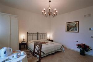 1 dormitorio con cama, mesa y lámpara de araña en Casa del Miele, en Tessera