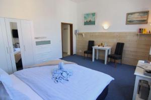 Kapitaenshaus-Lassen-Zimmer-Neptun في فيسترلاند: غرفة نوم بها سرير وطاولة وكراسي