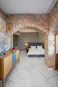 a bedroom with a bed and a stone wall at Vega Aparts in Gümüşlük +93 photos