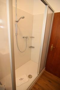 Kapitaenshaus-Lassen-Zimmer-Neptun في فيسترلاند: دش مع باب زجاجي في الحمام