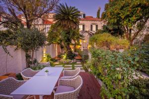 a garden with a white table and chairs at Heritage Villa Nobile in Dubrovnik