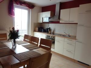 uma cozinha com mesa e cadeiras e uma cozinha com armários brancos em Ferienhaus NEMO em Rerik
