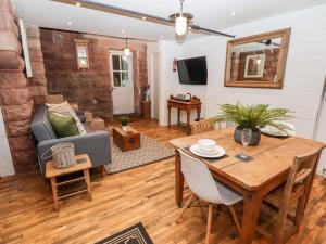 a living room with a wooden table and a dining room at Horton Lodge Boathouse in Leek