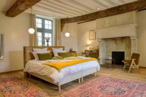 - une chambre avec un grand lit et une cheminée dans l'établissement Château de Bernesq, à Bernesq