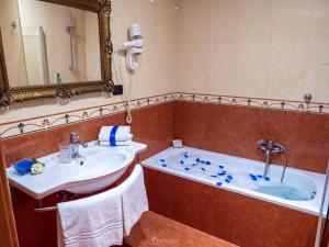 a bathroom with a tub and a sink and a mirror at Caroline Suite in Rome
