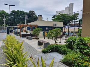 un parco con panchine e piante di fronte a un edificio di Apto de Praia Fiji 1102 a Piçarras