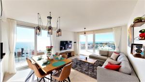 a living room with a couch and a table with chairs at Panoramica views superb luxury apartment in Fuengirola