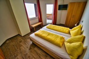 1 dormitorio con 1 cama con almohadas amarillas en Hotel Jungfrau en Fiesch