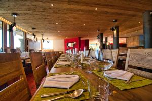 a dining room table with a wooden table and chairs at Hotel Jungfrau in Fiesch