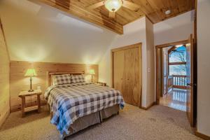 a bedroom with a bed and a wooden ceiling at Contemporary ADK 5 Bedroom Chalet on Schroon in Schroon Lake