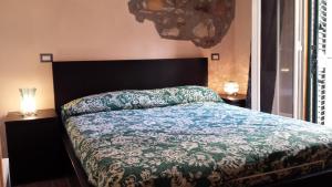 sypialnia z łóżkiem z zieloną kołdrą w obiekcie Madema B&B w Cefalù