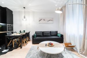 uma sala de estar com um sofá preto e uma mesa em EdSam Madrid Apartments Black em Madri