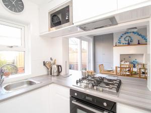 a kitchen with a stove top oven next to a sink at Seaforth in Swanage