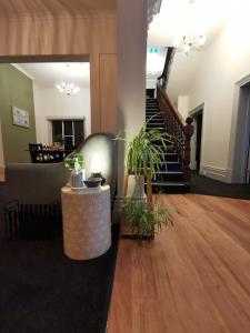 a living room with a couch and a table with plants at Refresh109 on Cameron in Launceston