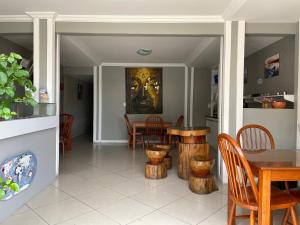 a dining room with a table and chairs and a painting at Pousada Veleiro in Fortaleza