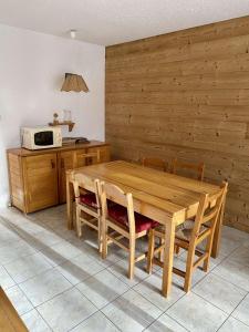 eine Küche mit einem Holztisch mit Stühlen und einer Mikrowelle in der Unterkunft Boost Your Immo Prapelier Les Deux Alpes 430 in Les Deux Alpes