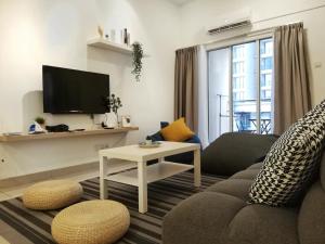 ein Wohnzimmer mit einem Sofa und einem TV in der Unterkunft Subang City Residence, 8-9 pax with Balcony, Walking Distance to Summit, 5min to Sunway in Subang Jaya
