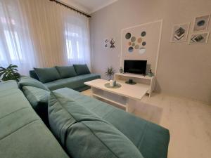 Cozy apartment in Kikinda في Kikinda: غرفة معيشة مع أريكة وطاولة