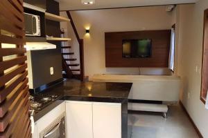 a kitchen with a sink and a stove in a room at Casa Bonfim - Excelente opção no centro de Arraial in Porto Seguro +3 photos