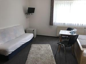 um pequeno quarto com uma cama, uma secretária e uma mesa em Landgasthof Krone em Lauterach