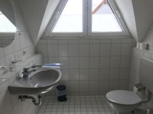 La salle de bains est pourvue d'un lavabo et de toilettes. dans l'établissement Landgasthof Krone, à Lauterach