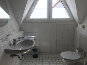 a bathroom with a sink and a toilet at Landgasthof Krone in Lauterach +26 photos