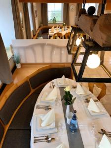 a table in a restaurant with white plates and napkins at Landgasthof Krone in Lauterach