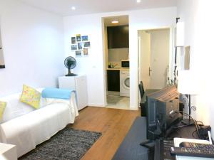 a living room with a white couch and a tv at Wonderful Studio in Lisbon in Lisbon