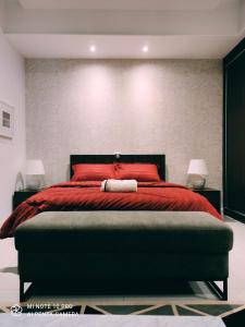 a bedroom with a red bed with red pillows at Kumkum Homestay Studio in Nusajaya
