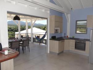 eine Küche und ein Esszimmer mit Blick auf eine Terrasse in der Unterkunft Les Balcons du Parc in Petit-Bourg