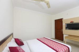a bedroom with a bed and a tv on a wall at Hotel Half Moon Chennai in Chennai