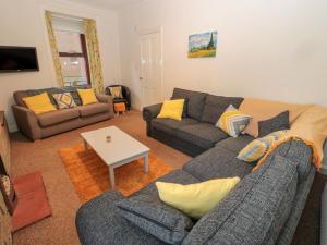 a living room with two couches and a table at Harbour Retreat in Eyemouth