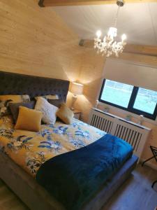 a bedroom with a bed and a chandelier at The Lodge Mountain View Log Cabin , Attymass Ballina in Boyhollagh