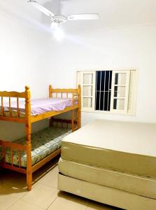 ein Schlafzimmer mit zwei Etagenbetten und einem Fenster in der Unterkunft Peruibe centro mar 944 in Peruíbe